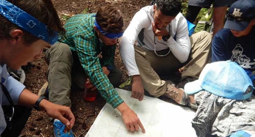 a group of outward bound gap year students examine a map